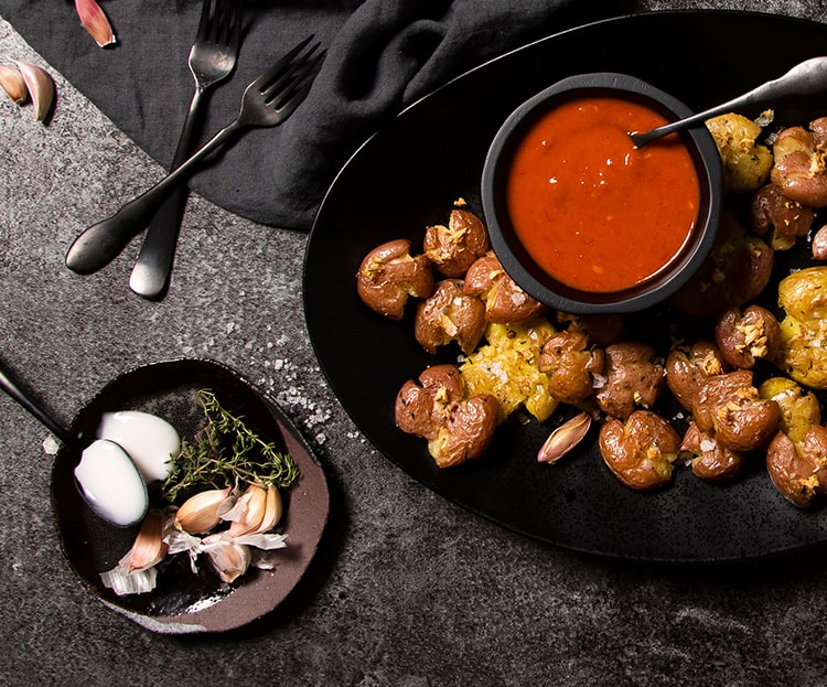 Garlic Smashed Potatoes With Harissa Yogurt Topping